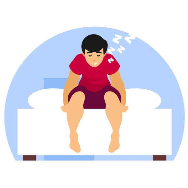 Sleepy man sits on his bed